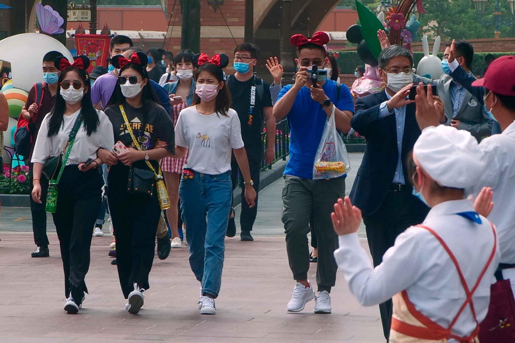 Shanghai, China Disneyland visitors wearing face masks and mouse ears