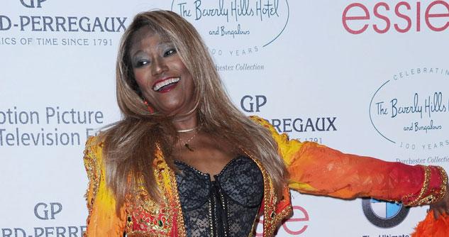 Bonnie Pointer in a bright orange and yellow jacket and black top