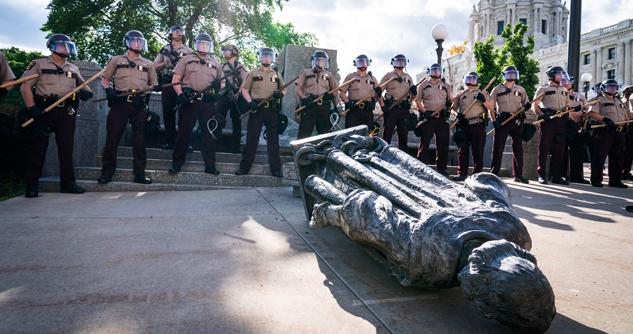 Minnesota State Troopers surrounded the statue of Christopher Columbus after it was toppled