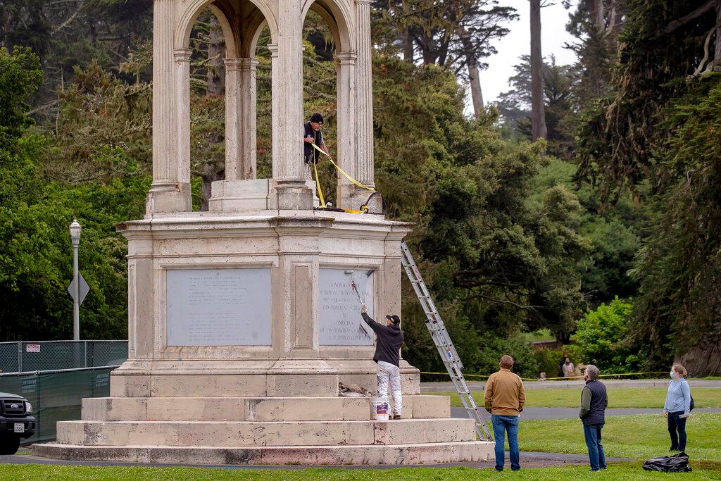 Workers from the Recreation and Parks Department paint over graffiti after a statue of Francis Scott Key was toppled from its pedestal in Golden Gate Park in San Francisco