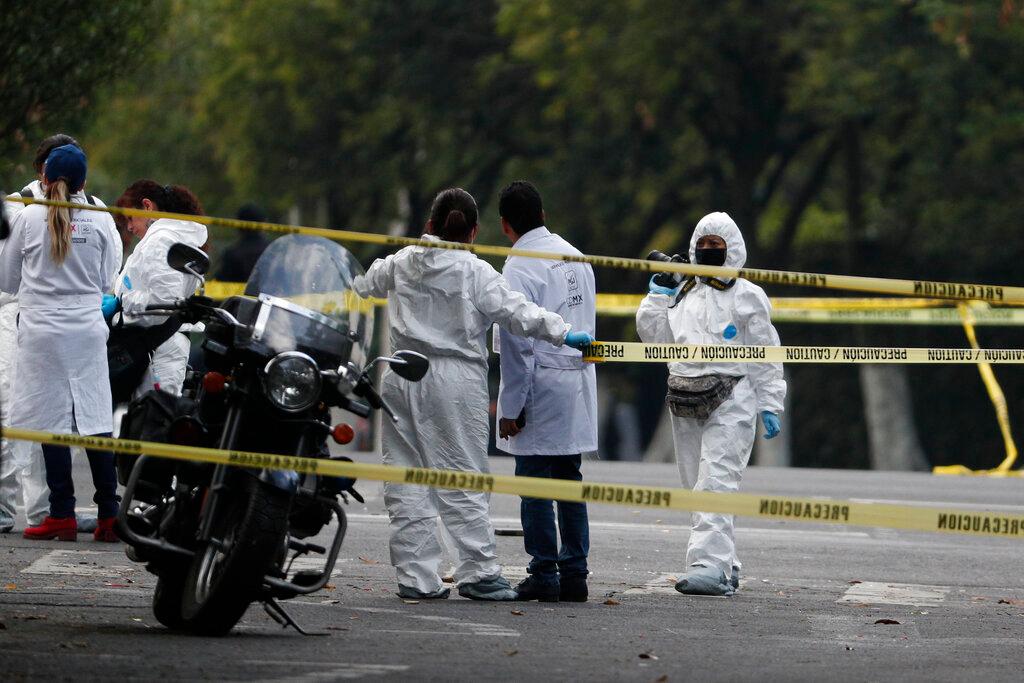 Forensic investigators and police work the scene where security secretary, Omar García Harfuch, was attacked by gunmen in the early morning hours in Mexico City