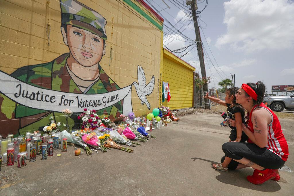 Dawn Gomez holds her 3-year-old granddaughter, Saryia Greer, who waves at Vanessa Guillen's mural painted by Alejandro "Donkeeboy" Roman Jr. on the side of Taqueria Del Sol, Thursday, July 2, 2020, in Houston. Army investigators believe Guillen, a Texas soldier missing since April, was killed by another soldier on the Texas base where they served, the attorney for the missing soldier's family said Thursday.
