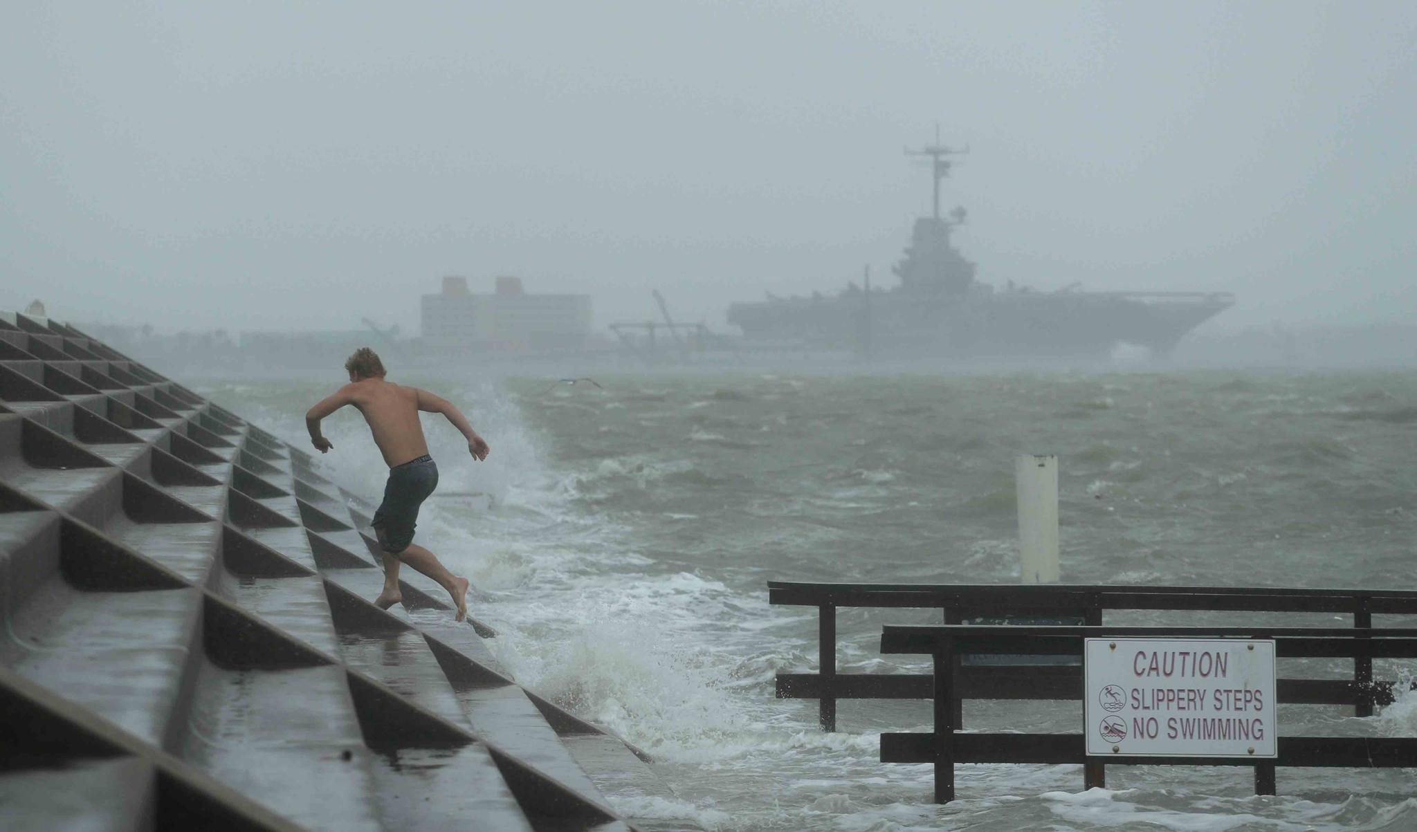 A man jumps from a wave as Hurricane Hanna begins to make landfall, Saturday, July 25, 2020, in Corpus Christi, Texas.