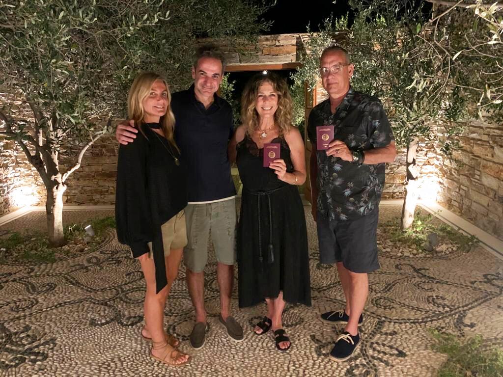 Greek Prime Minister Kyriakos Mitstotakis, second left, his wife Mareva Grabowski-Mitsotaki, left, pose next to U.S. actor Tom Hanks , right, and his wife Rita Wilson holding up their new Greek passports