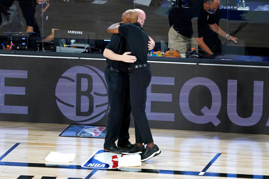 Steve Clifford, left, and Brooklyn Nets head coach Jacque Vaughn hug before the start of NBA basketball game in Lake Buena Vista, Fla.