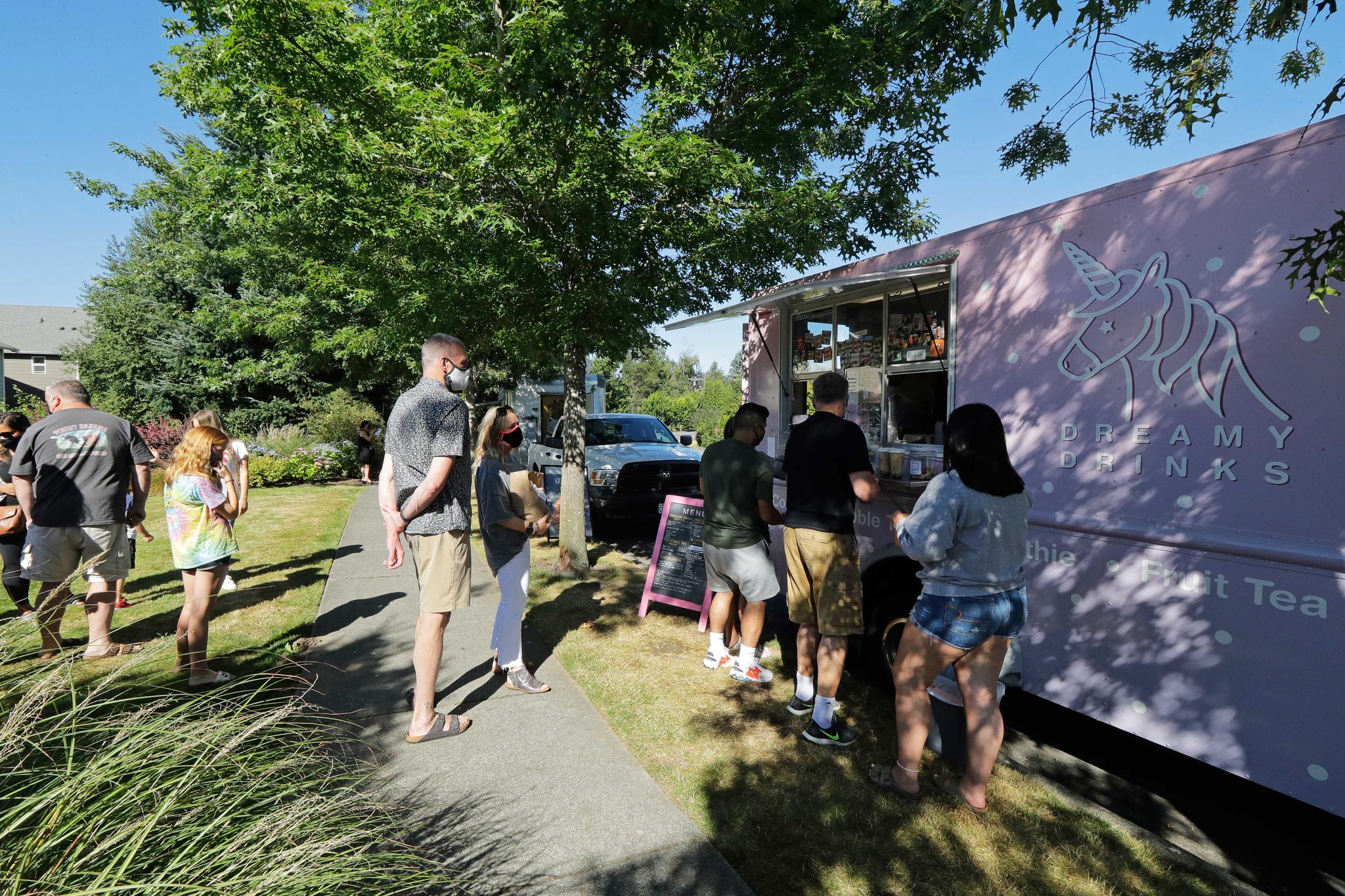 Customers line up to order from a food truck