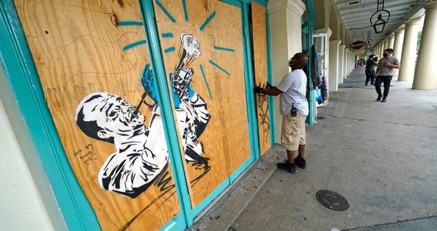 Workers board up shops in the French Quarter of New Orleans