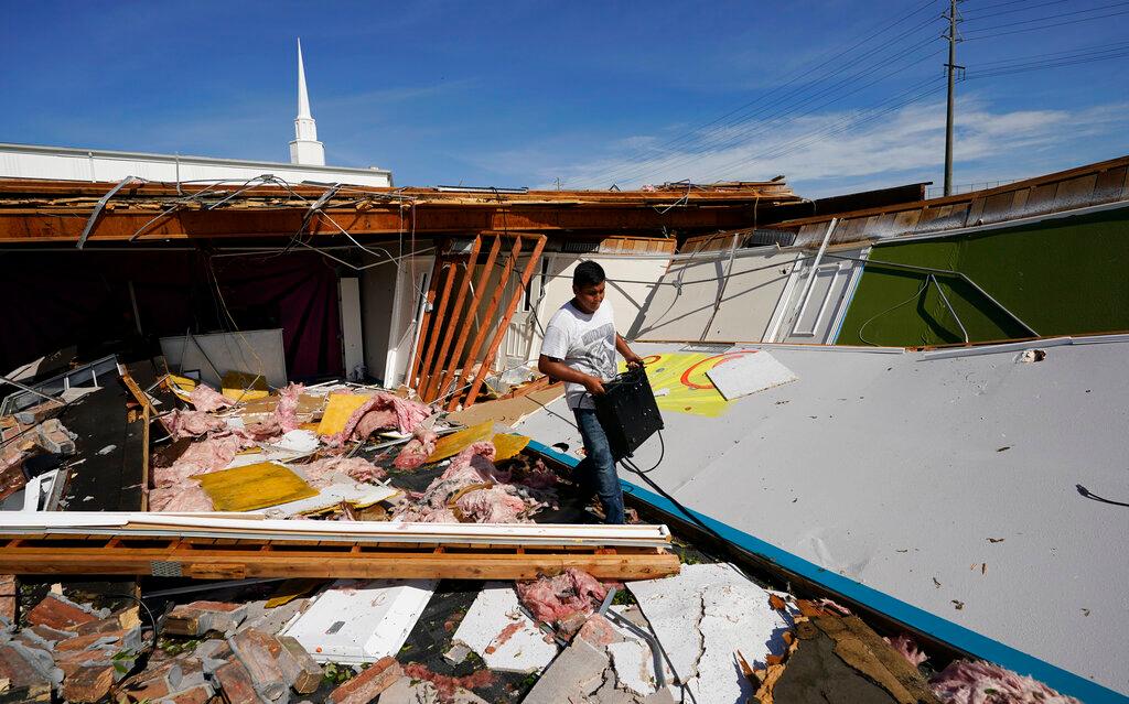 Benjamin Luna helps recover items from the children's wing of the First Pentecostal Church that was destroyed by Hurricane Laura in Orange, Texas