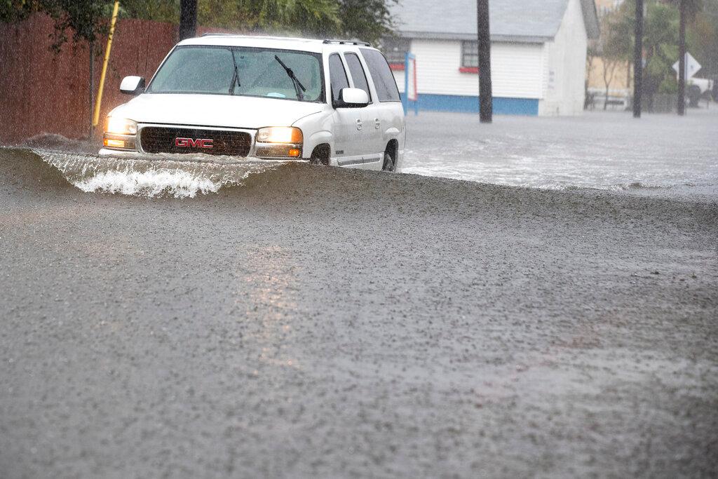 SUV driving over flooded road 