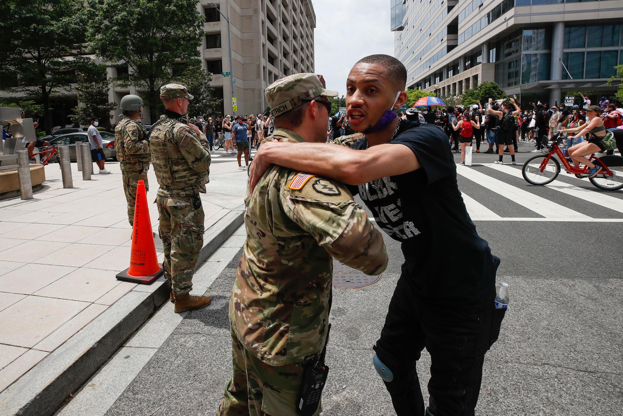 a demonstrator hugs a National Guard soldier
