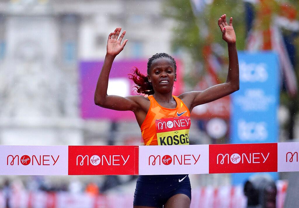 Kenya's Brigid Kosgei crosses the line to win the London Marathon in London, England, Sunday, Oct. 4, 2020. Athletes are competing on a 26.2-mile (42.2-kilometer) closed-loop course consisting of 19.6 clockwise laps around St. James' Park. The traditional course along the River Thames was scrapped because of the coronavirus pandemic and only elite men and women are competing and no spectators are permitted.