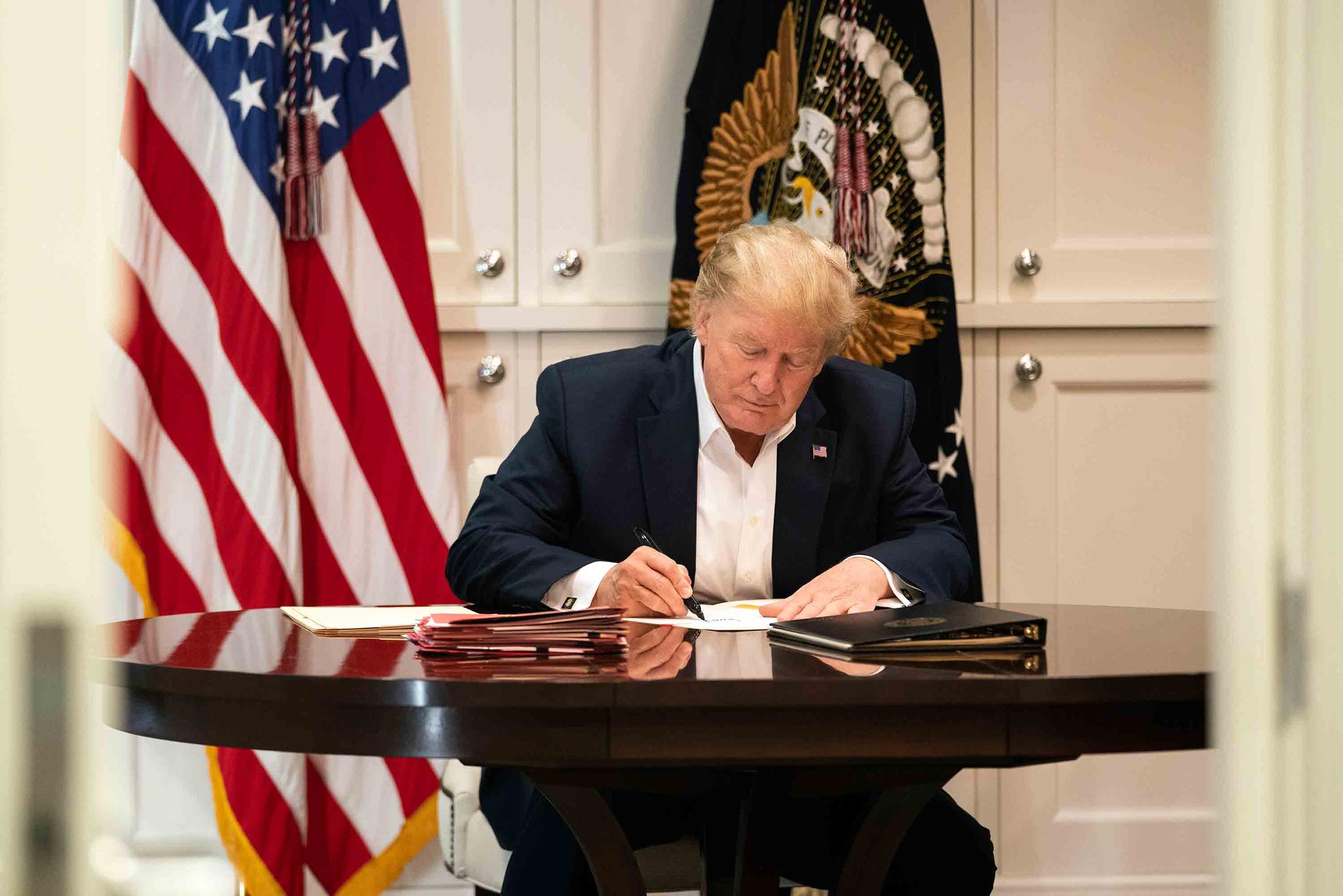 In this image released by the White House, President Donald Trump works in the Presidential Suite at Walter Reed National Military Medical Center in Bethesda, Md.