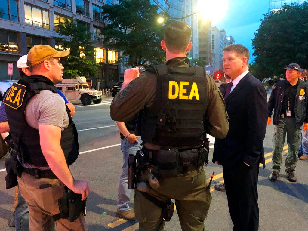 Acting Drug Enforcement Administrator Timothy Shea, right, visits with DEA agents at a checkpoint in Washington