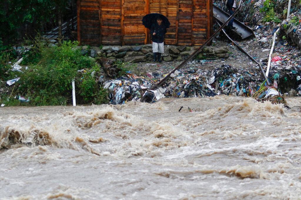 A man watches the rising water of the Rio Bermejo in the wake of Hurricane Iota in San Pedro Sula, Honduras, Tuesday, Nov. 17, 2020. 