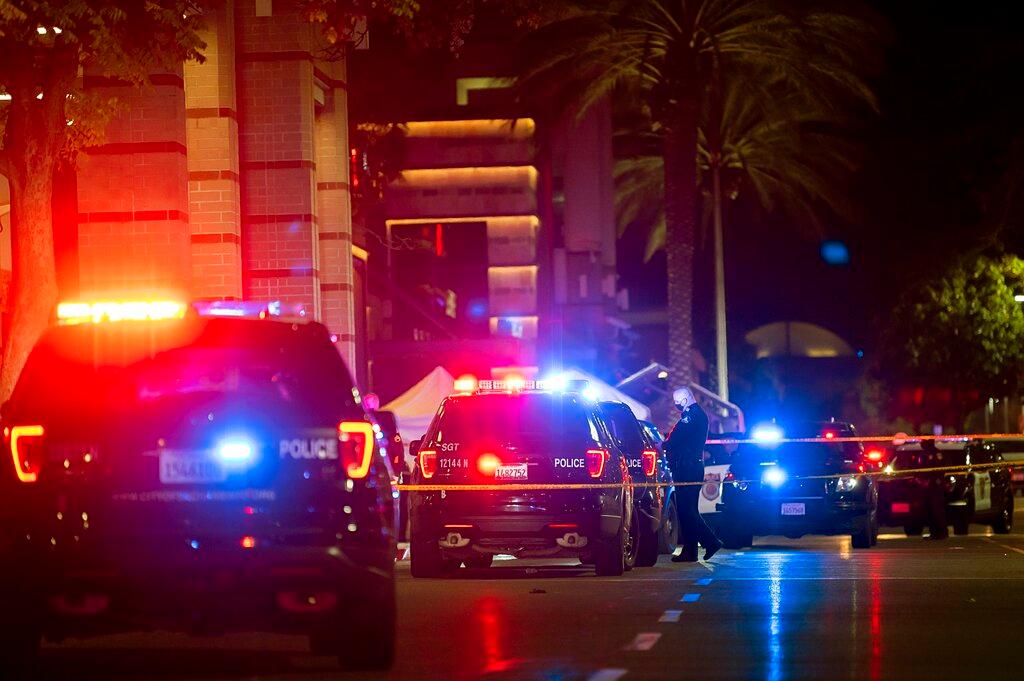 Police stand outside Arden Fair Mall after a shooting that left one person dead and another critically injured, Friday, Nov. 27, 2020, in Sacramento, Calif. The mall was evacuated in the midst of Black Friday, one of the busiest shopping days. Police later said the suspect had fled and there was no active threat to the mall. 