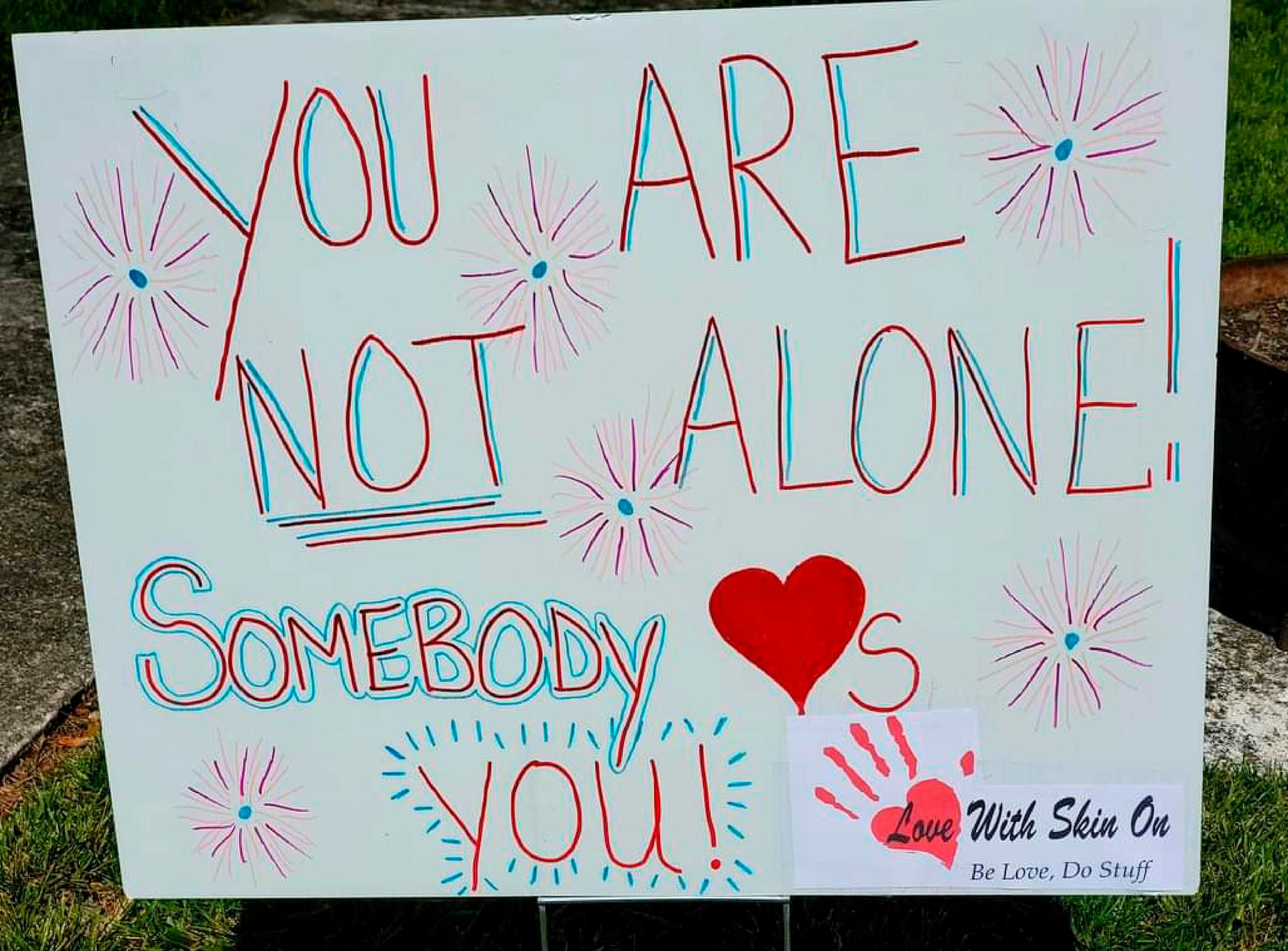 sign that says 'you are not alone, somebody loves you'