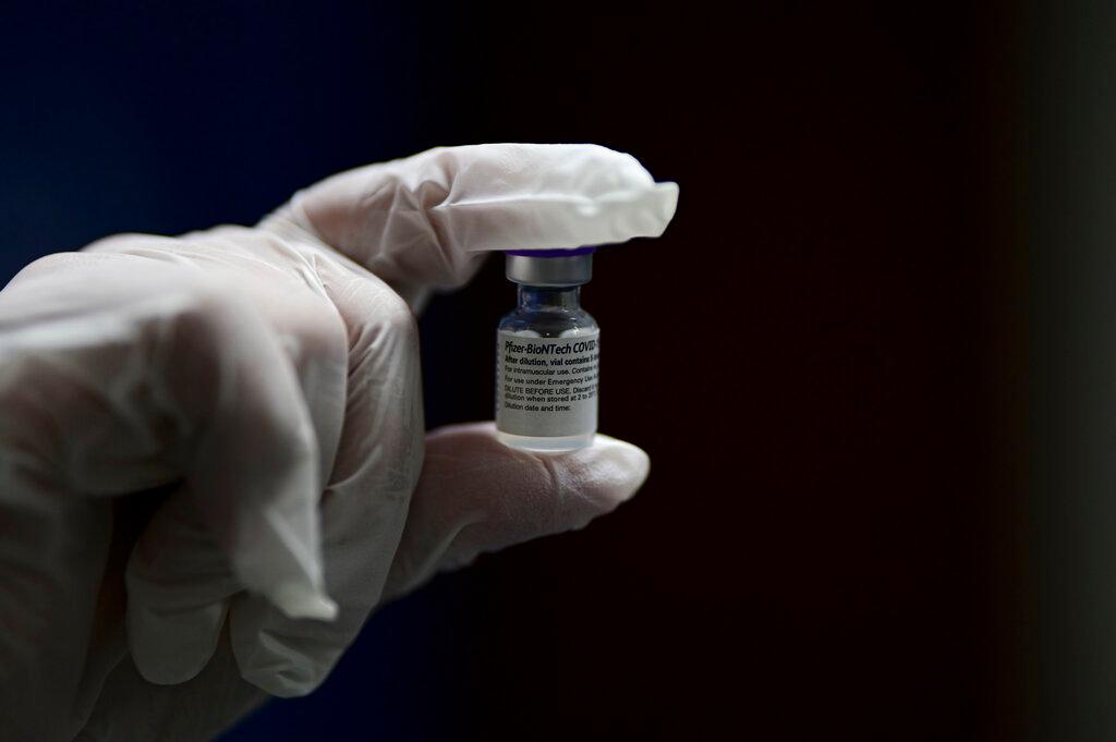 Nurse Melissa Valentin shows a dose of the Pfizer-BioNTech COVID-19 vaccine