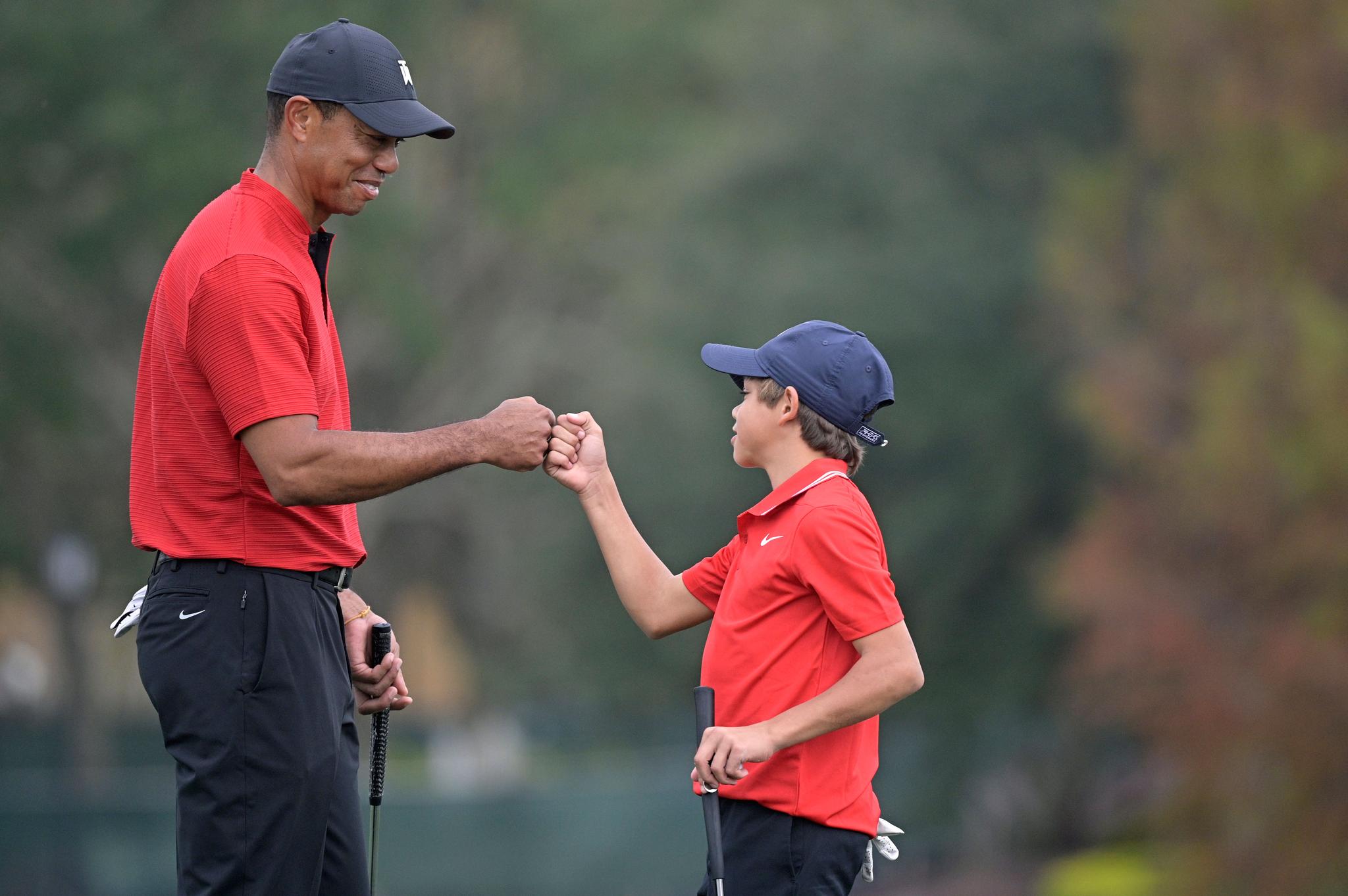 Tiger Woods shares a fist bump with his son Charlie