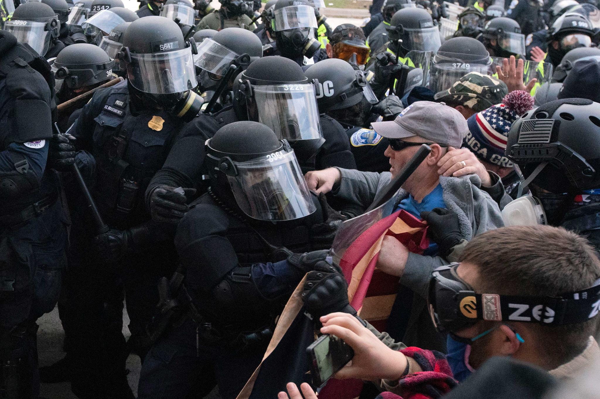 Capitol police officers push back demonstrators who try to break a door of the U.S. Capitol