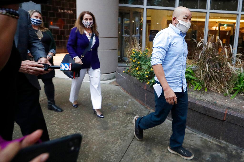 In this Jan. 21, 2021, photo former Houston Police Officer Tam Pham walks out of the Federal Courthouse downtown in Houston after he appeared in court following his arrest Wednesday on federal charges tied to Capitol violence. Police departments across the country are reviewing the behavior of dozens of officers who were in Washington on the day of a riot at the U.S. Capitol.