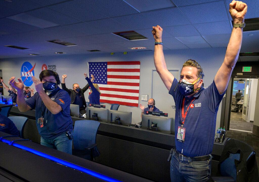 In this photo provided by NASA, members of NASA's Perseverance rover team react in mission control after receiving confirmation the spacecraft successfully touched down on Mars