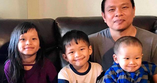 Dad on the couch with three small children