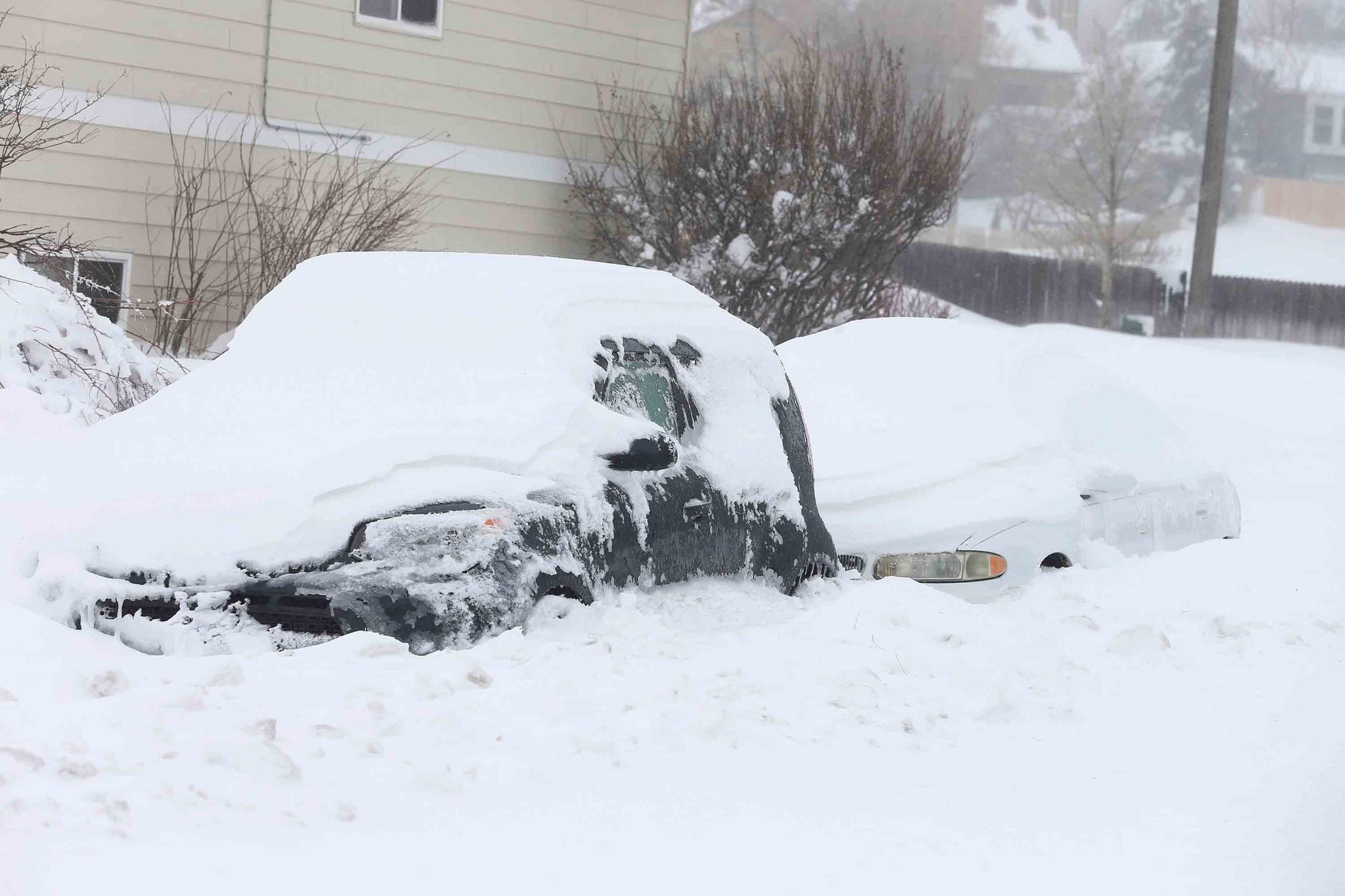 Vehicles sit surrounded in snow on Ridge Road in east Cheyenne, Wyo., Sunday, March 14, 2021.
