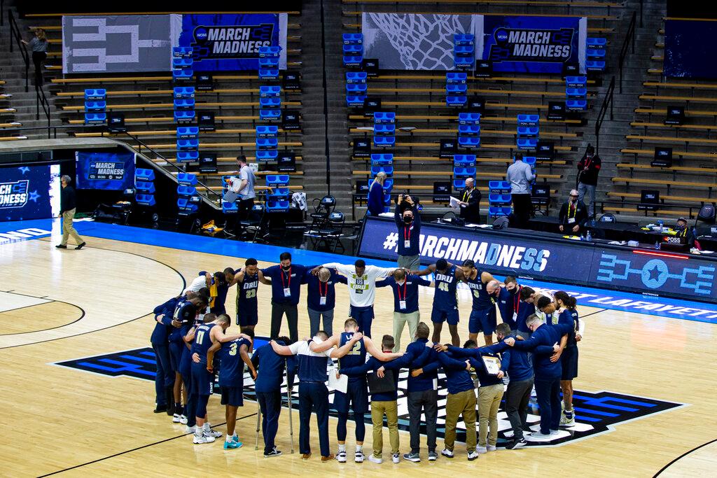 Oral Roberts players and coaches form a prayer circle on the court following their win over Ohio State in a first-round game in the NCAA men's college basketball tournament