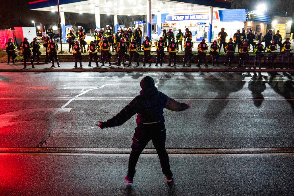 Demonstrator heckles authorities who advanced into a gas station after issuing orders for crowds to disperse