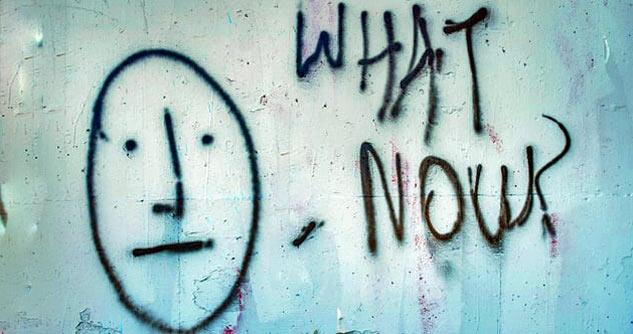 Graffiti worried face with question What Now?