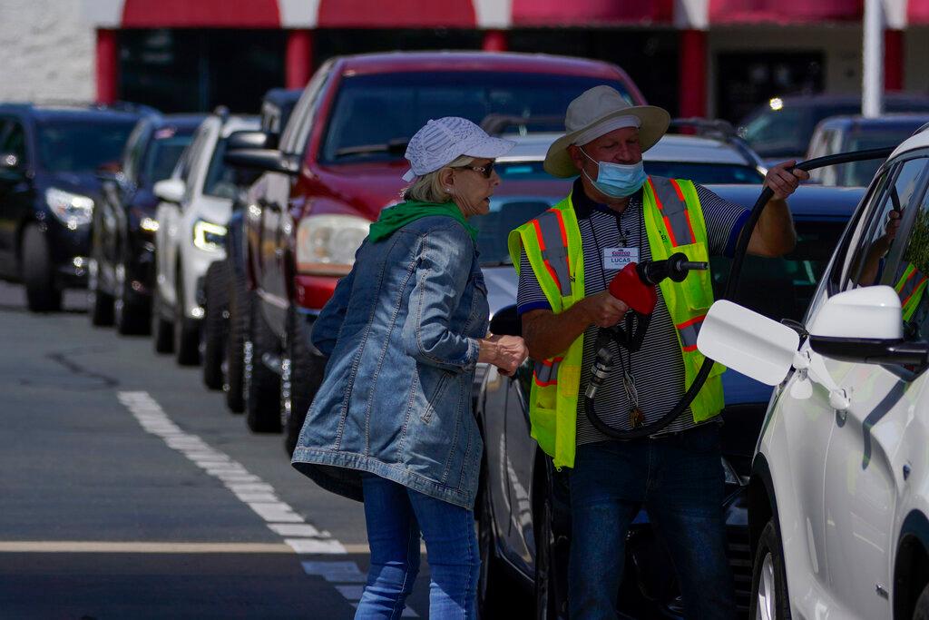 A customer gets help pumping gas at Costco in Charlotte, N.C.