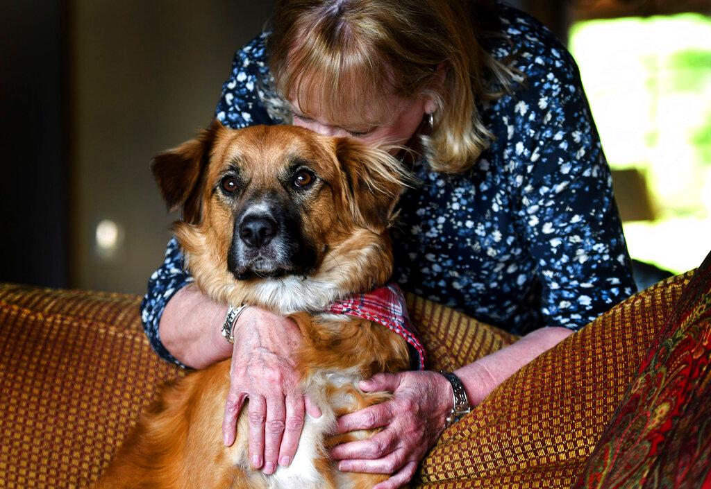 Linda Oswald hugs 2-year-old dog Tilly at their home in Hayden, Idaho