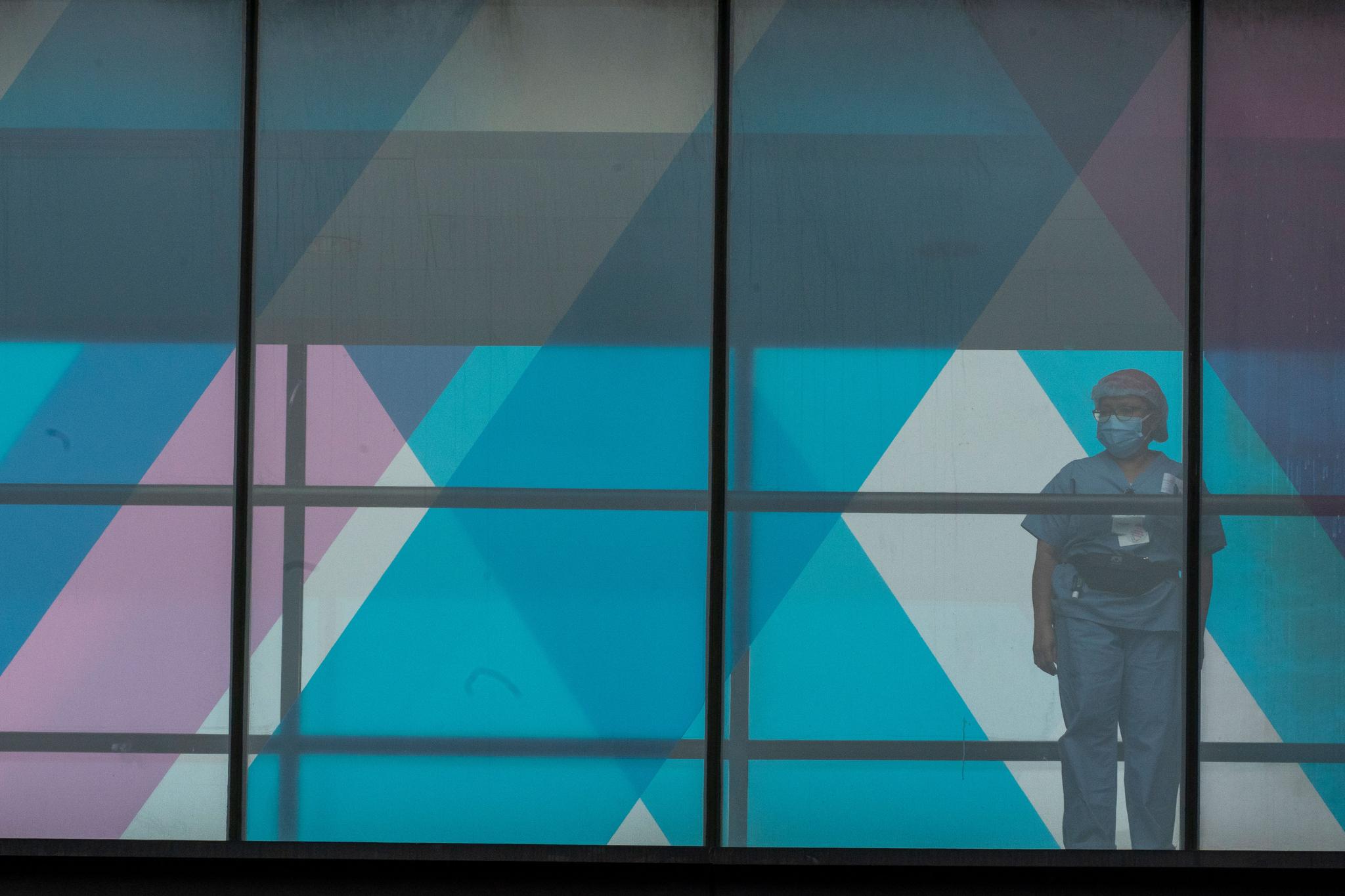 health care worker looks out a window