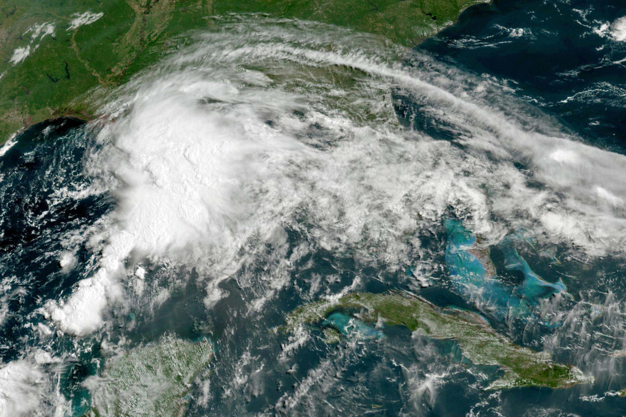 This GOES-16 GeoColor satellite image taken Friday, June 18, 2021, at 11 a.m. EDT, and provided by NOAA, shows a tropical weather system in the Gulf of Mexico. Officials ordered a floodgate and locks system closed in southeast Louisiana and readied sandbags in Mississippi and Alabama as a broad, disorganized tropical weather system began spinning bands of rain and brisk wind across the northern Gulf of Mexico coast Friday.