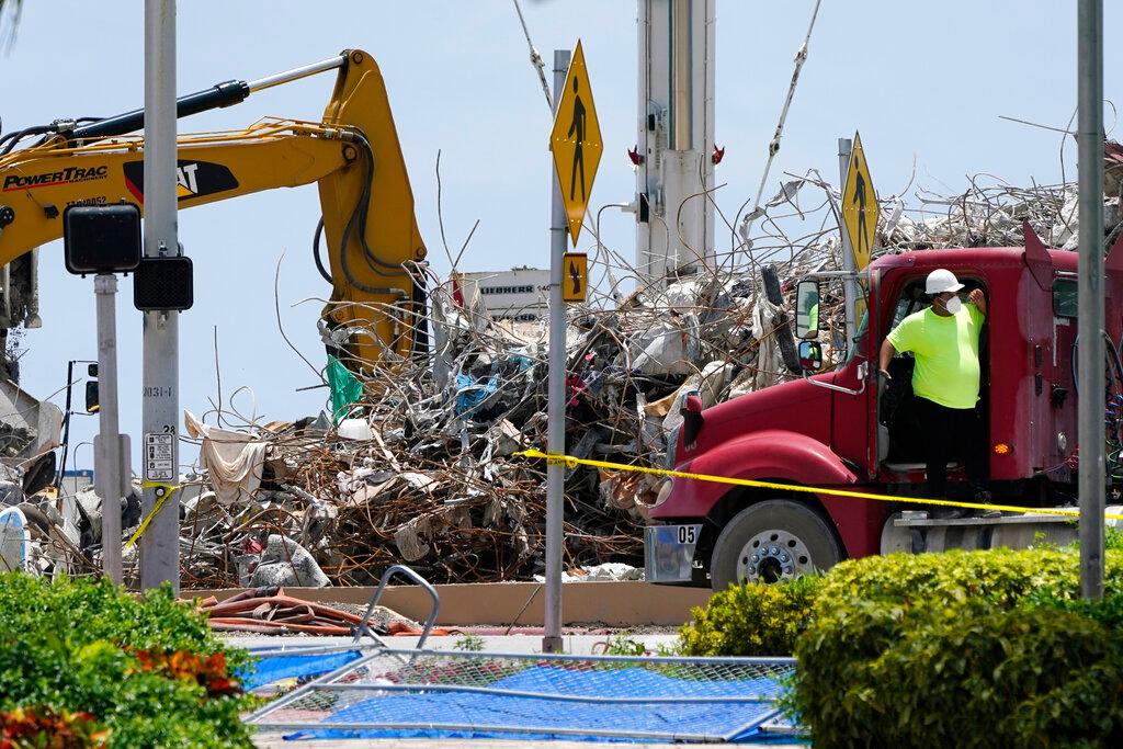 Workers hauling away debris from condo collapse 