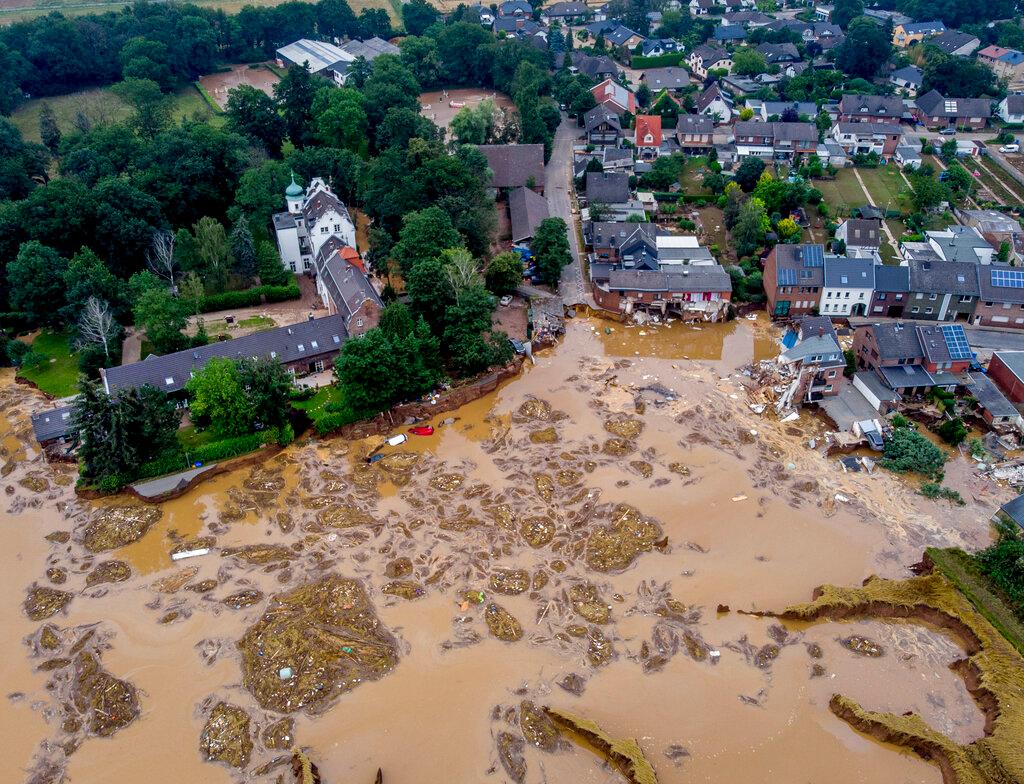 The damaged castle, left, is seen in Erftstadt-Blessem, Germany, Saturday, July 17, 2021. Due to strong rain falls the small Erft river went over the banks causing massive damages.