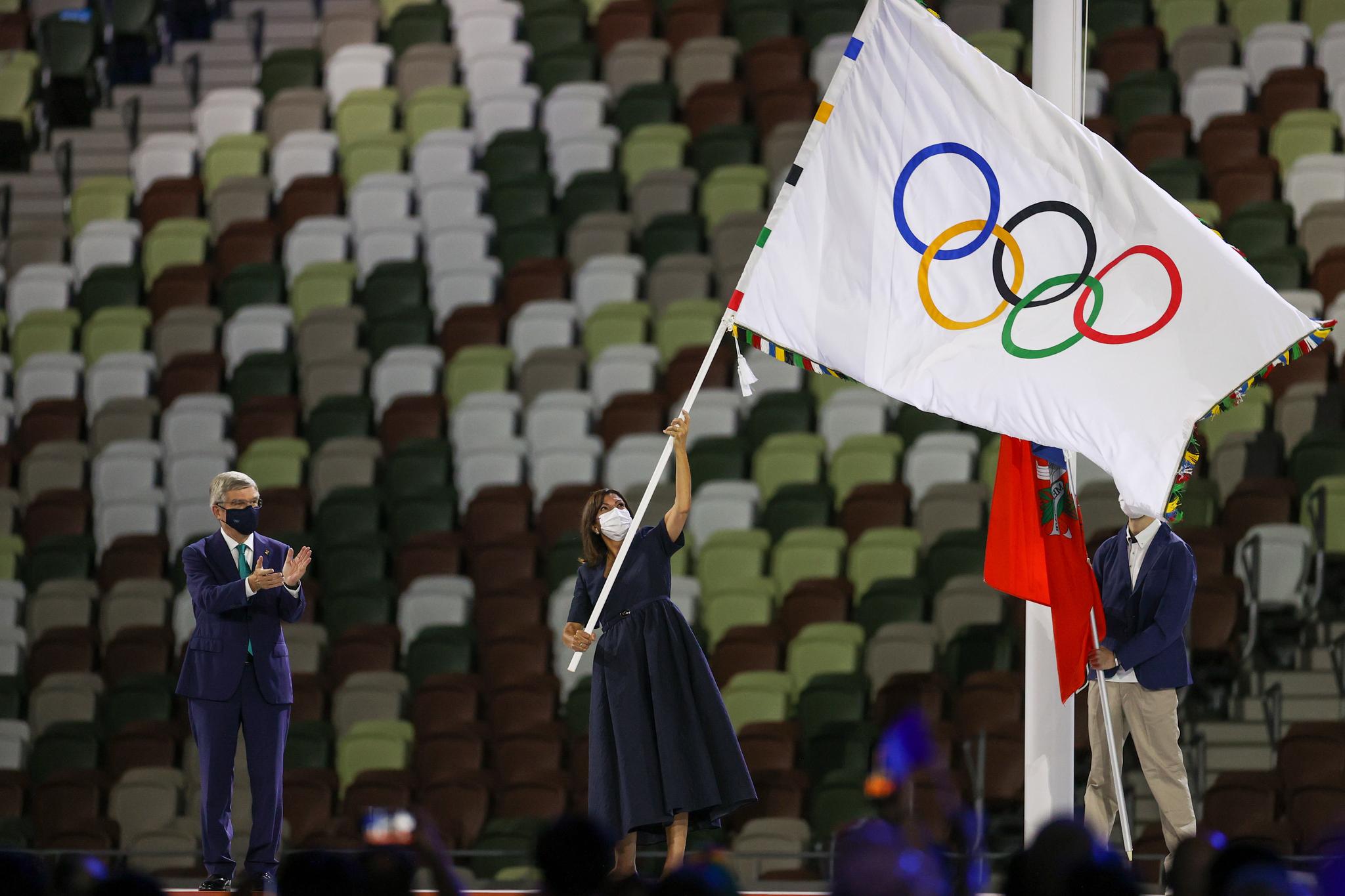 Paris Mayor Anne Hidalgo waves the Olympic flag 