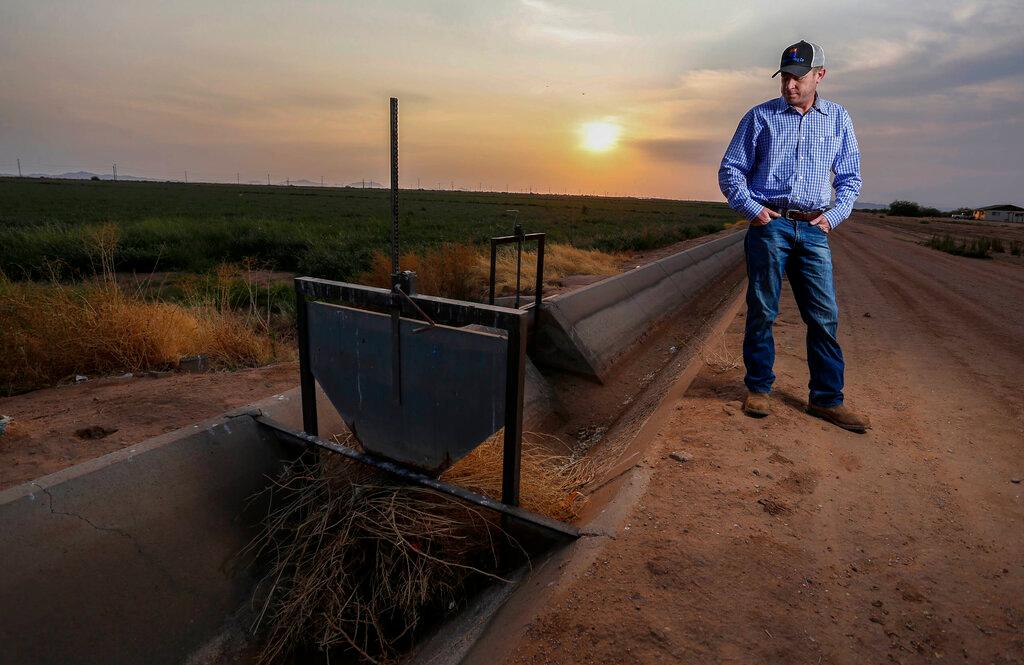 Farmer Stands By Dry Irrigation Canal 