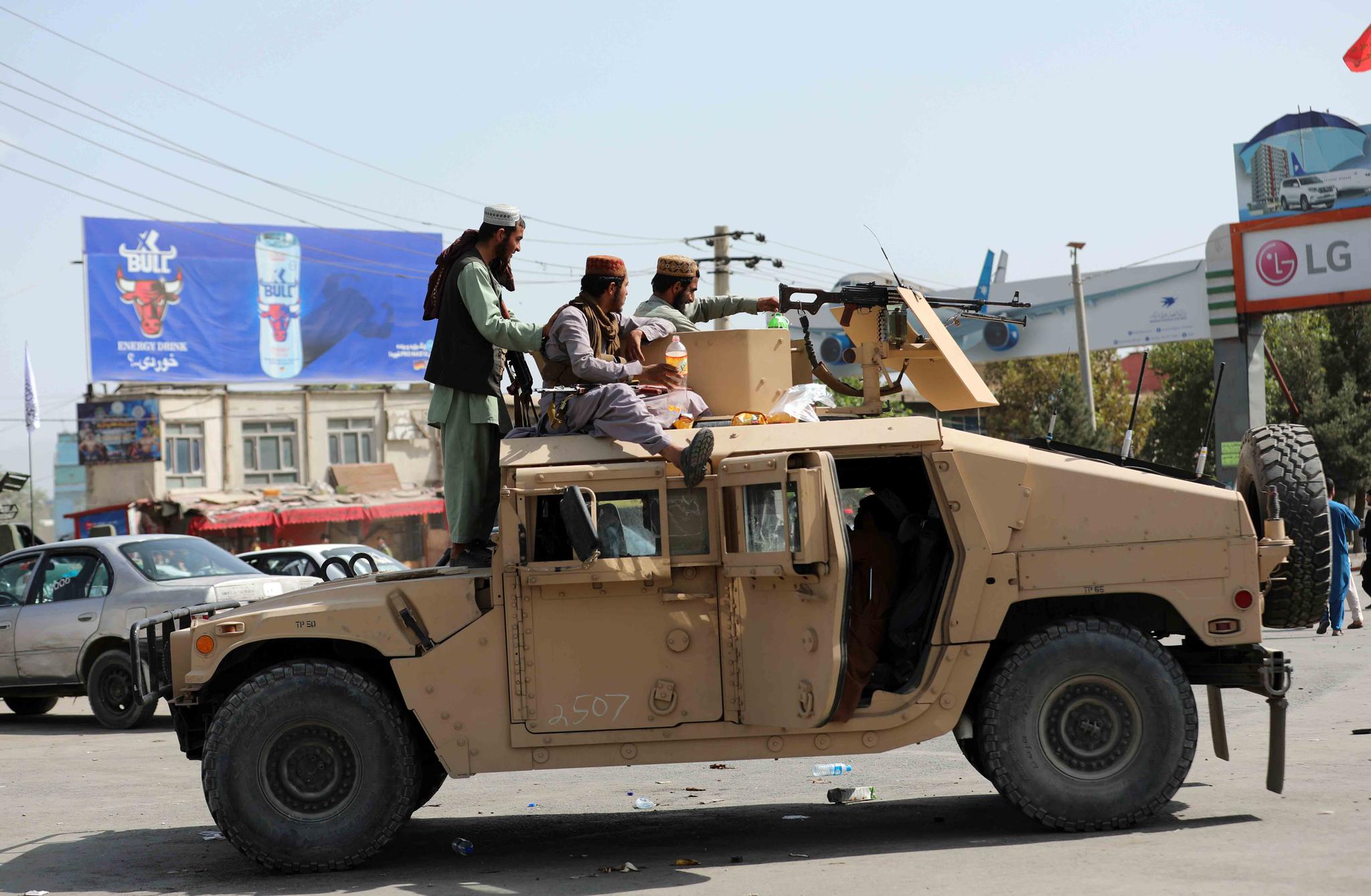 Taliban fighters stand guard in front of the Hamid Karzai International Airport, in Kabul, Afghanistan, Monday, Aug. 16, 2021.
