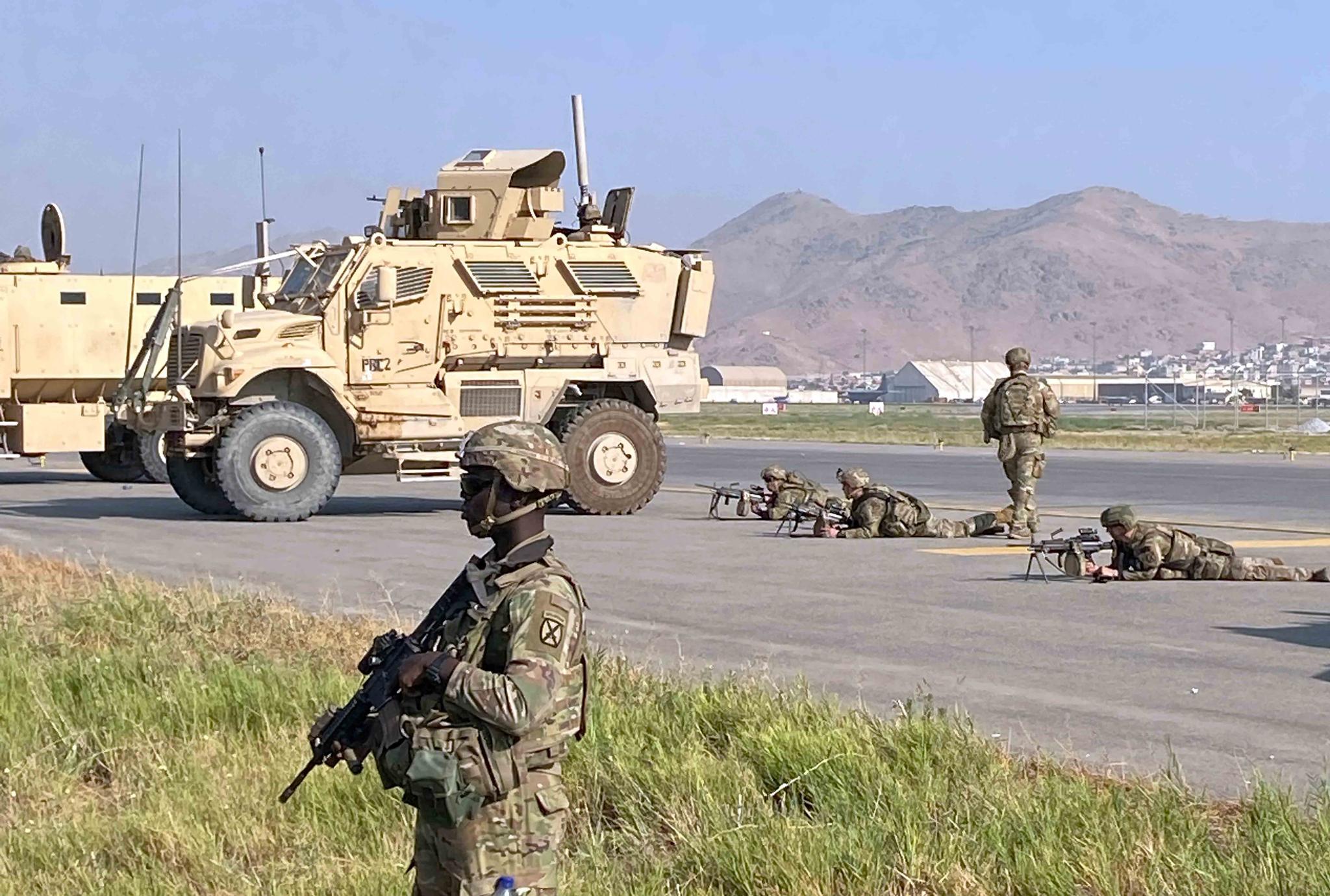 U.S soldiers stand guard along a perimeter at the international airport in Kabul, Afghanistan, Monday, Aug. 16, 2021.