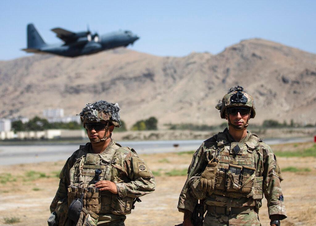 Two paratroopers assigned to the 1st Brigade Combat Team, 82nd Airborne Division conduct security while a C-130 Hercules takes off during a evacuation operation in Kabul, Afghanistan