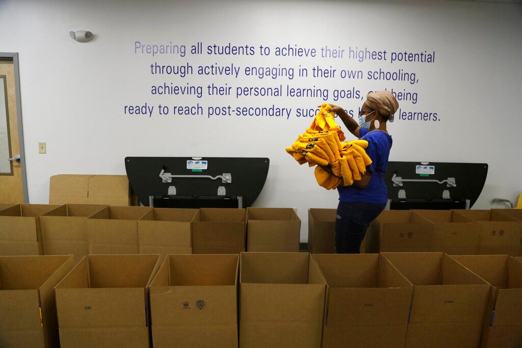 Stephanie Marshall, enrollment and marketing assistant at Agora Cyber Charter School, fills boxes with Agora supplies for family coaches to distribute to student