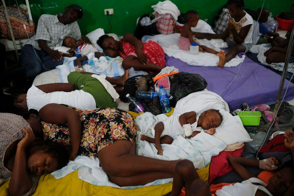 Injured children and their parents sleep on mattresses, on the floor of the Immaculee Conception hospital, in Les Cayes, Haiti