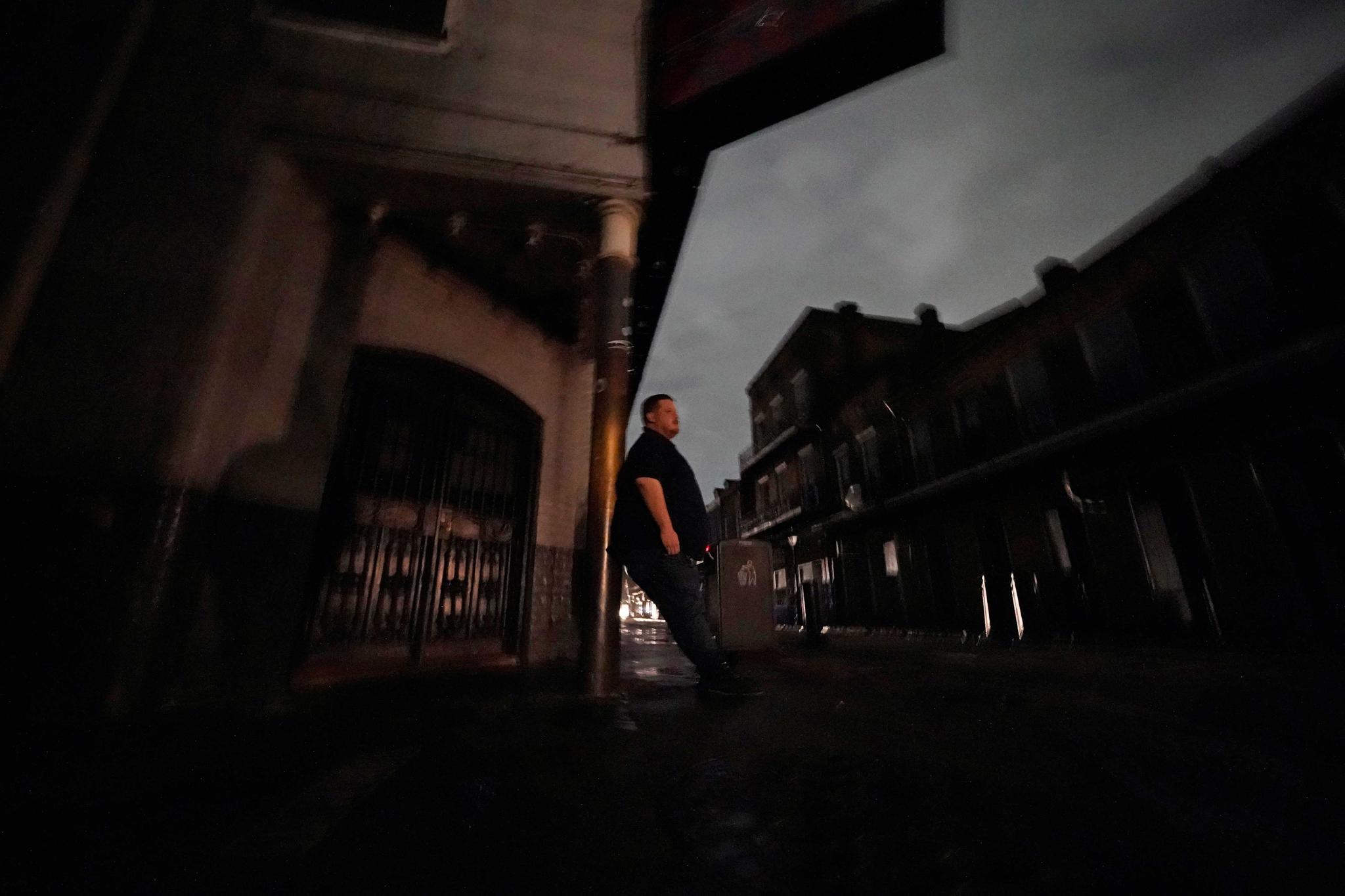 man stands outside during city wide power outage in New Orleans