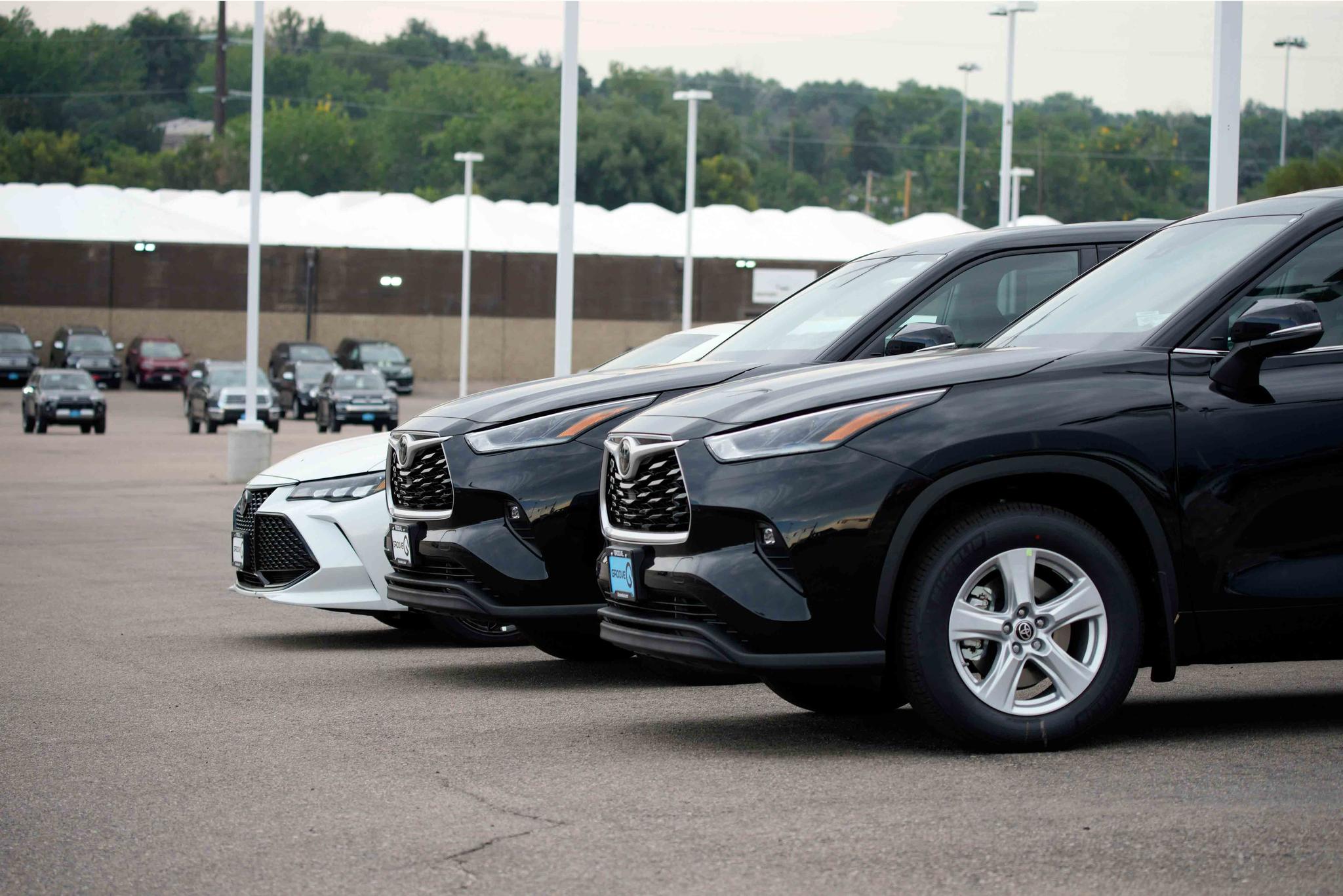 In this Sunday, Aug. 29, 2021, file photo, a pair of unsold 2021 Highlander sports utility vehicles and a Camry sedan are parked on the empty storage lot outside a Toyota dealership in Englewood, Colo.