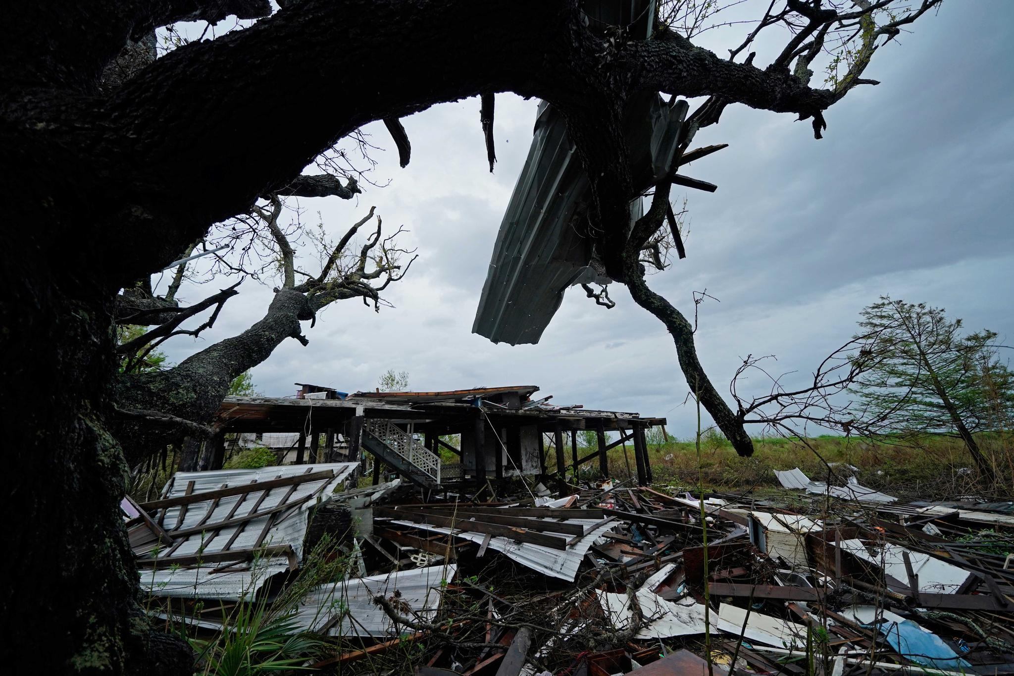 Storm clouds from Tropical Storm Nicholas near damaged home