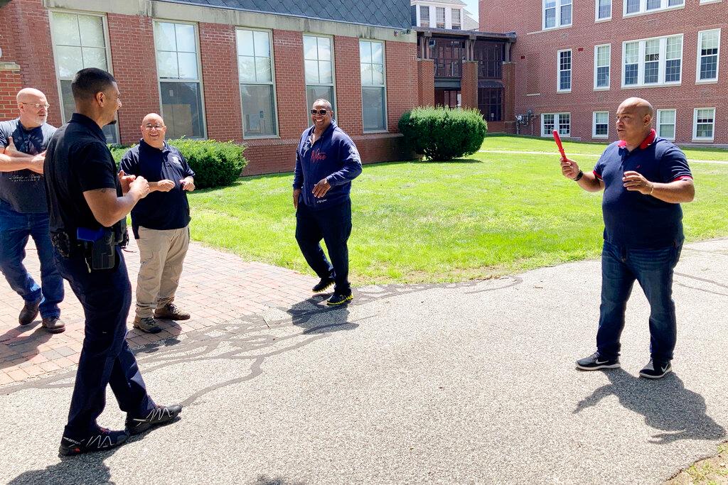 In this July 28, 2021 photo, Jose Otero from the New York City Police Department, right, holds a plastic knife after completion of a role-playing scenario in which New England police officers were learning de-escalation techniques from the Police Executive Research Forum in Saco, Maine.