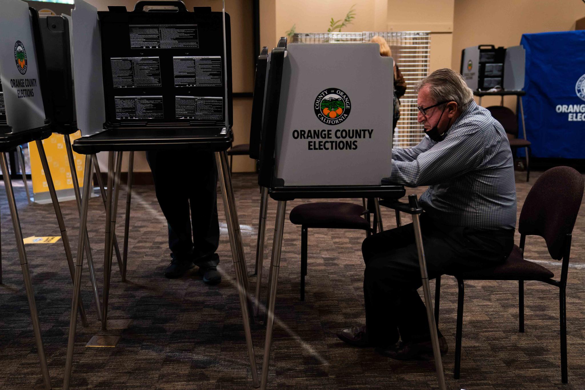In this Sept. 14, 2021, file photo, two voters cast their ballots at a vote center, in Huntington Beach, Calif. Every registered California voter will get a ballot mailed to them in future elections under a bill signed Monday, Sept. 27, 2021, by Democratic Gov. Gavin Newsom.