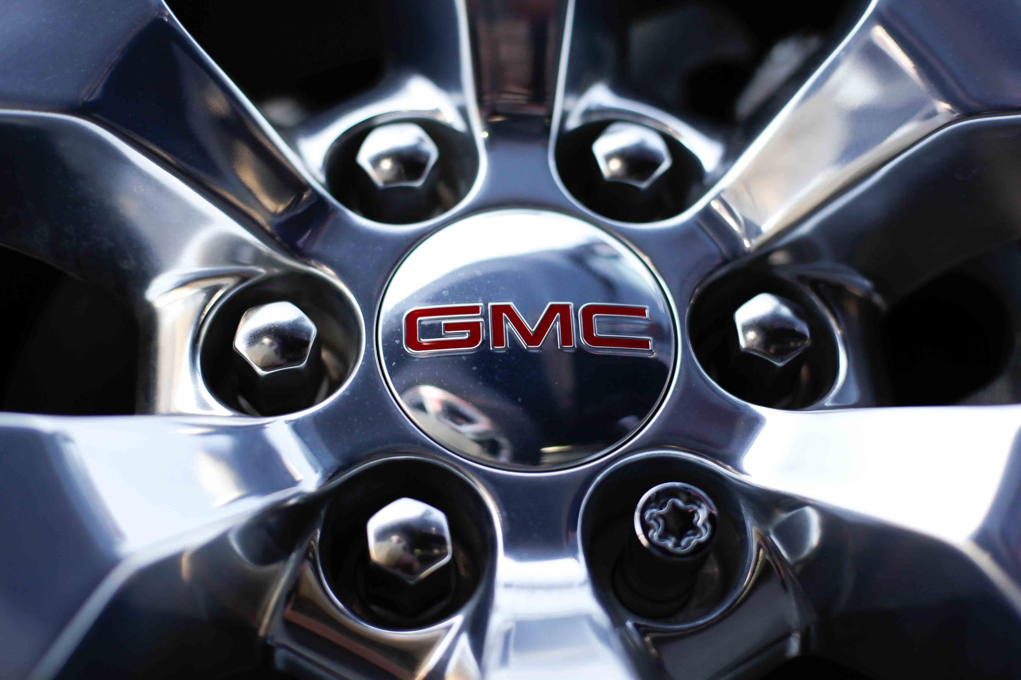 In this April 25, 2017 file, photo, a GMC logo is displayed on the wheel of a truck at a General Motors dealer's lot in Nashville, Tenn.