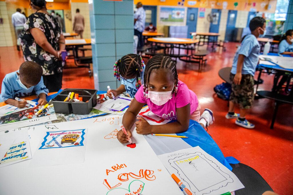 students write and draw positive affirmations on poster board at P.S. 5 Port Morris, an elementary school in The Bronx borough of New York